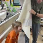 Charlotte taking her finished quilt off the frame! - Longarm quilted by Maynard Longarm Quilting