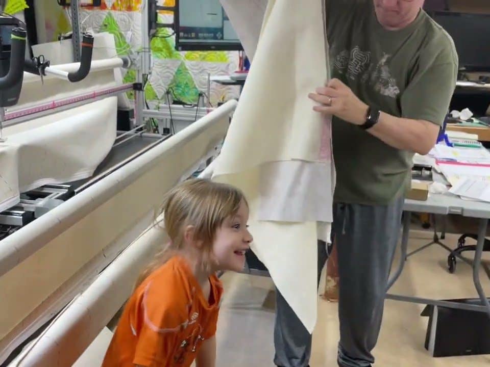Charlotte taking her finished quilt off the frame! - Longarm quilted by Maynard Longarm Quilting